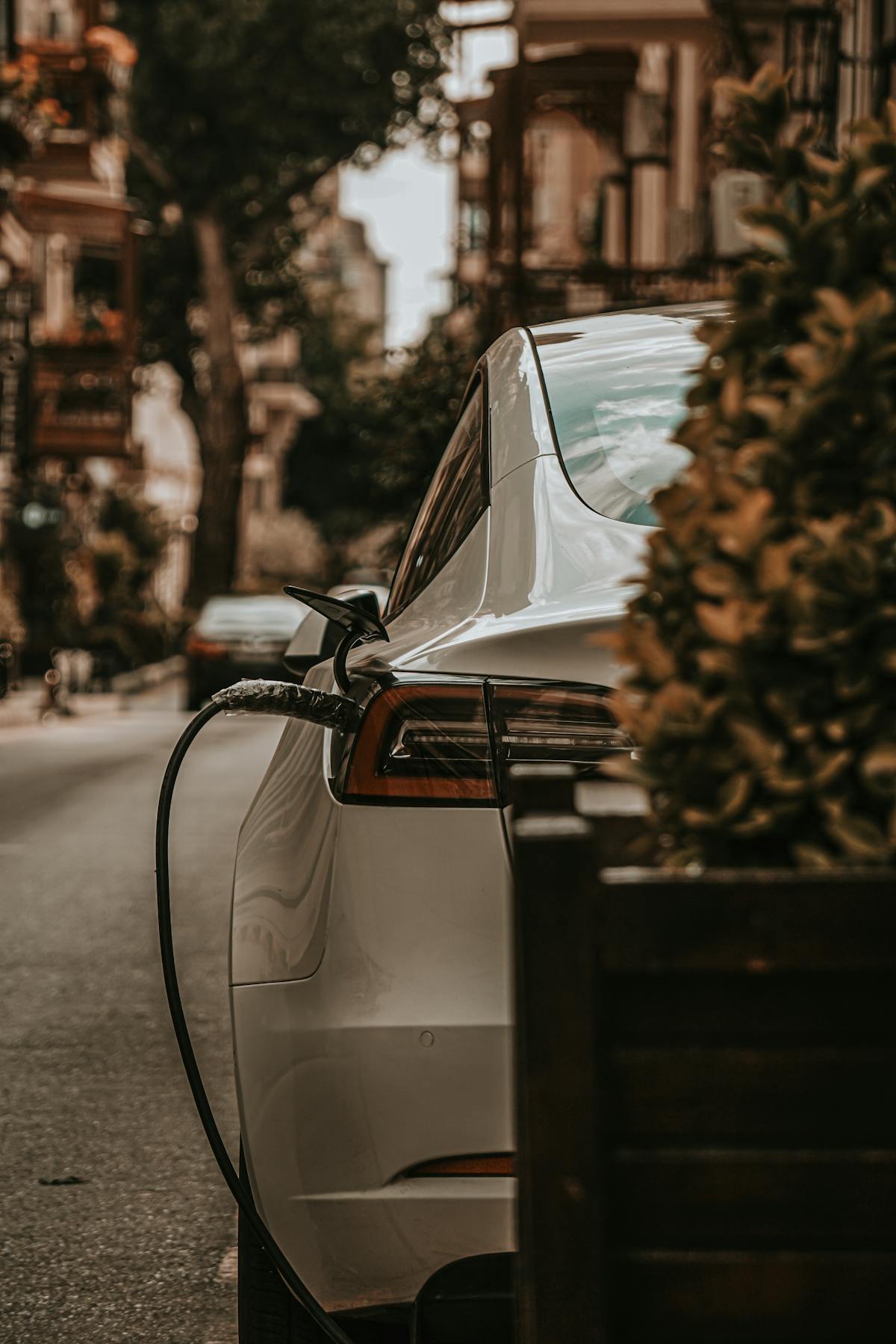 Electric vehicle charging on a street lined with residential apartment buildings