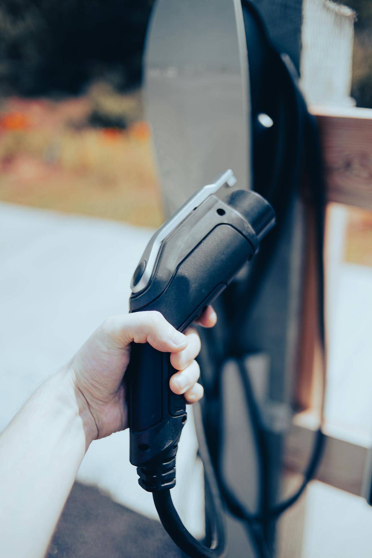 Hand holding an electric vehicle charging connector