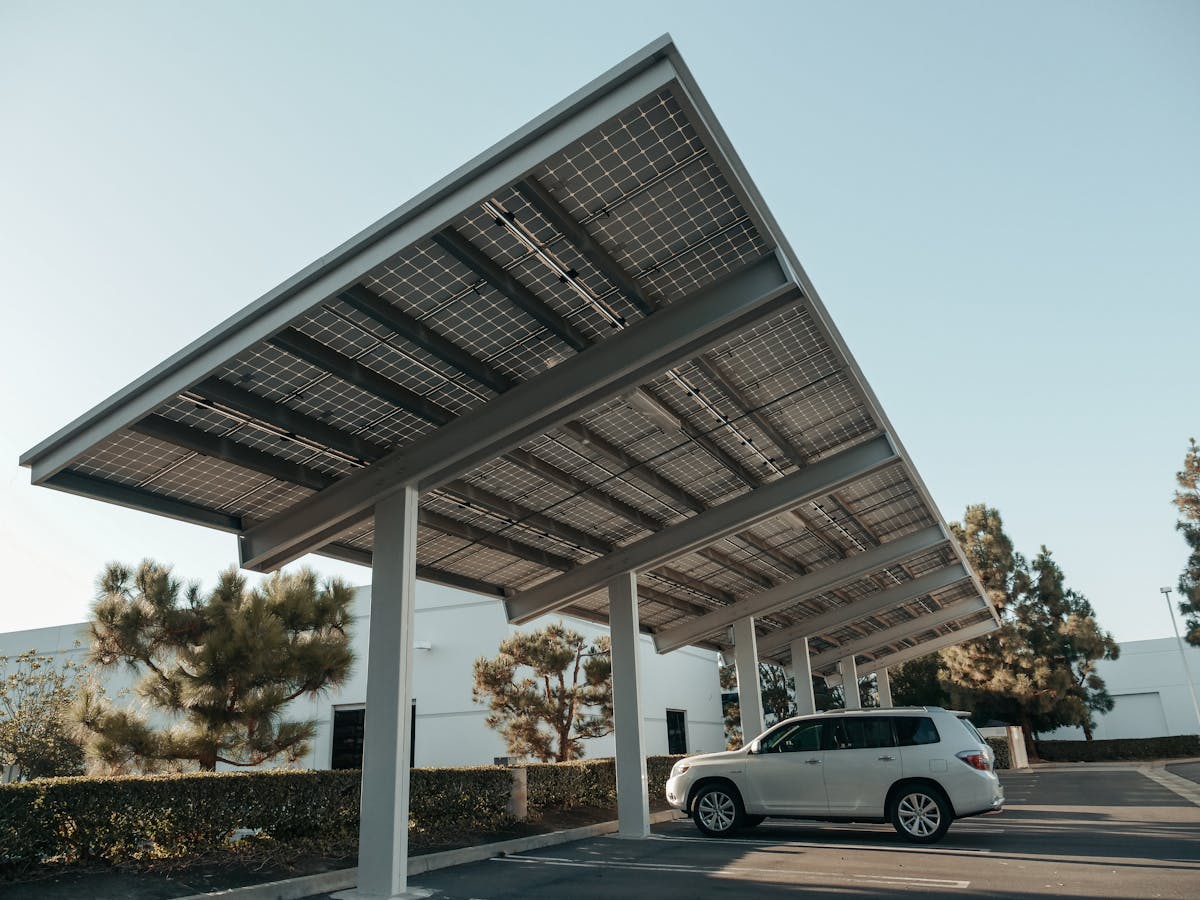 Photovoltaic canopy covering a car park with a vehicle parked underneath